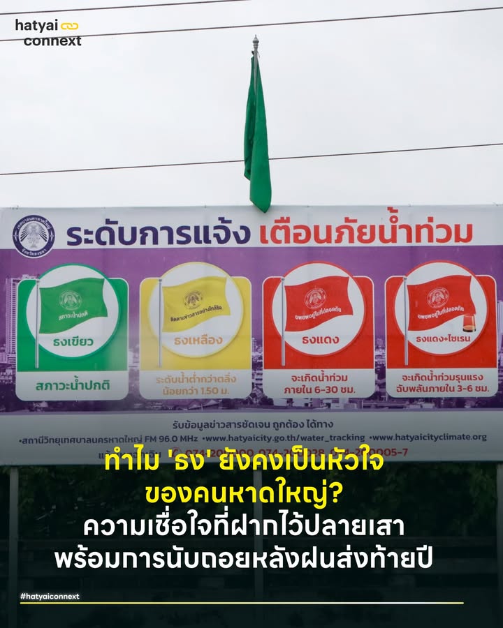 ทำไม 'ธง' ยังคงเป็นหัวใจ ของคนหาดใหญ่? ความเชื่อใจที่ฝากไว้ปลายเสาพร้อมการนับถอยหลังฝนส่งท้ายปี . นับถอยหลังอีกไม่กี่ชั่วโมงข้างหน้า หาดใหญ่กำลังจะเผชิญกับบททดสอบส่งท้ายปี 2568 ตามประกาศเตือนของกรมอุตุนิยมวิทยาที่ระบุว่าช่วงวันที่ 25-28 ธันวาคมนี้ จะมีมรสุมพาดผ่านและฝนตกหนักอีกระลอก . ในห้วงเวลาที่ความกังวลเริ่มก่อตัว นอกเหนือจากเกาะติดเพจที่รายงานเกี่ยวกับลมฟ้าอากาศ สายตาของชาวหาดใหญ่ก็โฟกัสไปที่สัญลักษณ์เฝ้าระวังอย่าง 'ธง 3 สี' (เขียว-เหลือง-แดง) ที่ปักอยู่ริมคลอง . ท่ามกลางโลกยุค AI และ IoT ที่ล้ำสมัย ระบบเตือนภัยน้ำท่วมของเมืองเศรษฐกิจแห่งนี้ กลับฝากหัวใจไว้กับสิ่งประดิษฐ์สุดคลาสสิกชิ้นนี้ คำถามที่น่าสนใจคือ มีเมืองไหนในโลกอีกไหมที่ใช้ระบบธงผ้าแบบนี้เตือนน้ำท่วมเมือง? . คำตอบคือ 'แทบไม่มีแล้วในระดับเมืองใหญ่ (Urban Scale)' . ในระดับสากล ระบบธง (Flag Warning System) มักถูกใช้ในบริบทของ 'ความปลอดภัยชายหาด' (Beach Safety) เพื่อเตือนคลื่นลม หรือใช้ในสนามแข่งรถ แต่สำหรับการเตือนภัยน้ำท่วมเมือง (Urban Flood) ประเทศพัฒนาแล้วอย่าง ญี่ปุ่น สหรัฐฯ หรือยุโรป เปลี่ยนไปใช้ 'Color-coded Digital Alert' หรือรหัสสีผ่านจอดิจิทัลและมือถือเกือบหมดแล้ว . แล้วทำไมหาดใหญ่ยังใช้? และระบบนี้ดีหรือไม่ดีอย่างไรในสายตาคนนอก? ลองมาวิเคราะห์กัน . #ทำไมคนหาดใหญ่ยังเชื่อธงมากกว่าแอป ต้องยอมรับว่าระบบธงของหาดใหญ่ประสบความสำเร็จมากในแง่ของ 'Psychological Anchor' หรือที่ยึดเหนี่ยวทางจิตใจ ซึ่งมีจุดแข็งที่เทคโนโลยีเลียนแบบไม่ได้ (Analog Trust) . 1. ความน่าเชื่อถือ (Trust) - คนหาดใหญ่เชื่อ 'ธง' มากกว่ากราฟิกบนหน้าจอ เพราะธงตั้งอยู่ริมน้ำจริงๆ เห็นระดับน้ำกับตาจริงๆ ความเรียบง่ายนี้สร้าง Trust มานานหลักสิบปี . 2. ความเสถียร (Resilience) - ในสถานการณ์ภัยพิบัติที่ไฟดับ อินเทอร์เน็ตล่ม หรือแอปฯ ล่ม 'ธง' ยังคงโบกสะบัดอยู่ตรงนั้น มันคือระบบ Analog ที่ไม่มีวัน Error ตราบใดที่เสายังปักอยู่ . 3. ความเข้าใจง่าย (Universal Design) - ไม่ต้องรู้หนังสือ ไม่ต้องมีสมาร์ทโฟน เห็นสีก็รู้เรื่องทันที (เขียว=รอด, เหลือง=เก็บของ, แดง=หนี) . #จุดอ่อนและBugของระบบธงในยุคใหม่ แม้จะขลัง แต่ระบบธงมีข้อจำกัดทางกายภาพที่อันตรายในยุคปัจจุบัน โดยเฉพาะเรื่อง Latency (ความล่าช้า) เพราะการเปลี่ยนสีธงต้องใช้ 'คน' เดินทางไปเปลี่ยน หากน้ำมาเร็วมาก หรือเจ้าหน้าที่ติดพันภารกิจอื่น การเปลี่ยนธงอาจช้ากว่าสถานการณ์จริง (Real-time Lag) . รวมถึงเรื่อง Visibility (การมองเห็น) ที่กลางคืนมองไม่เห็น ฝนตกหนักมองไม่ชัด และที่สำคัญคือ 'ถ้าคุณไม่ได้อยู่หน้างาน คุณก็ไม่เห็น' คนที่อยู่ห่างออกไปต้องรอฟังข่าวบอกต่อ ซึ่งอาจเกิดการบิดเบือนได้ . นอกจากนี้ยังมีความหยาบของข้อมูล (Lack of Granularity) ธงเหลืองของแต่ละคนไม่เท่ากัน 'เหลือง' คือเตรียมตัว 1 ชั่วโมง หรือ 5 ชั่วโมง? ระบบสีบอกแค่ 'สถานะ' แต่ไม่บอก 'เวลา' (Time-frame) ที่เหลืออยู่ . #คนอื่นใช้อะไรแทนธง ญี่ปุ่น เขาไม่ได้ใช้แค่ธง แต่ใช้ 'ระบบระดับการเตือนภัย 1-5' ที่ระบุสีและคำสั่งชัดเจนผ่าน 'ทีวีทุกช่อง, แอปฯ ในมือถือ และป้ายดิจิทัล' จุดเด่นคือการ นิยามให้เป็นรหัสสีที่เข้าใจง่ายและบังคับใช้จริง ระดับ 3 (สีแดง) ผู้สูงอายุต้องเริ่มอพยพ ระดับ 4 (สีม่วง) ทุกคนต้องอพยพทันที (ไม่ใช่แค่แนะนำ) ระดับ 5 (สีดำ) วิกฤตสูงสุด ภัยถึงตัวแล้ว ให้รักษาชีวิตในจุดที่ปลอดภัยที่สุด ข้อมูลเหล่านี้ถูกส่งผ่านระบบ J-Alert ยิงตรงเข้ามือถือพร้อมเสียงไซเรนเตือนภัย ทำให้ประชาชนรู้ตัวพร้อมกันทั้งเมืองโดยไม่ต้องรอฟังข่าวบอกต่อ จุดเด่นคือมีการระบุชัดเจนว่า สีนี้ = ต้องอพยพผู้สูงอายุ สีนี้ = อพยพทุกคน และมีการยิง Alert เข้ามือถือระบุพิกัดทันที . ส่วน 'สหรัฐอเมริกา' เมื่อเกิดภัยพิบัติระดับวิกฤต (Flash Flood Emergency) เขาใช้ระบบ Wireless Emergency Alerts (WEA) ซึ่งก็คือเทคโนโลยี Cell Broadcast มาตรฐานเดียวกับที่หาดใหญ่กำลังเริ่มใช้ . จุดเด่นคือระบบจะยิงข้อความแจ้งเตือนพร้อม 'เสียงไซเรนพิเศษ' ดังลั่นออกจากมือถือทุกเครื่องในพื้นที่เสี่ยงทันที แม้จะปิดเสียงหรือไม่มีเน็ตก็ตาม โดยที่ประชาชนไม่ต้องโหลดแอปพลิเคชันใดๆ เพิ่มเติม . #ทางออกไม่ต้องทิ้งธงแต่ต้องทำให้Smart หาดใหญ่ไม่จำเป็นต้องเลิกใช้ธง เพราะมันคือ 'แบรนด์' แห่งความเชื่อมั่นของเมือง แต่ควร Upgrade สู่ระบบ 'Hybrid Warning System' . - Digital Twin สถานะธงต้องไม่อยู่แค่ริมคลอง แต่ต้องอยู่บน Widget หน้าจอมือถือ บนป้าย LED จราจรทั่วเมือง และบนหน้าเว็บไซต์เทศบาลแบบ Real-time ทันทีที่เจ้าหน้าที่เปลี่ยนธงจริง ธงในโลกออนไลน์ต้องเปลี่ยนด้วยวินาทีเดียวกัน หรือการทำประกาศที่มีสี (CI) ชัดเจนที่ใช้เพื่อสื่อสารเกี่ยวกับเรื่องน้ำ . - เพิ่ม 'ความหมาย' ให้กับสี (Define the Code) ถอดบทเรียนจากญี่ปุ่น คือต้องนิยาม Action Plan ของแต่ละสีให้ชัดกว่านี้ เช่น ธงเหลือง ไม่ใช่แค่ 'เฝ้าระวัง' แต่ต้องระบุว่า 'น้ำจะถึงตัวเมืองภายใน X ชั่วโมง' (ใช้ Data มาคำนวณให้ได้ผลใกล้เคียง) . - Sensor-based Flag (ธงอัตโนมัติ) ในจุดที่ห่างไกล ควรใช้ 'ธงไฟ LED' ที่เปลี่ยนสีอัตโนมัติตามระดับน้ำจากเซนเซอร์ (Telemetering) ลดความเสี่ยงของเจ้าหน้าที่และลดความล่าช้า . ระบบธงของหาดใหญ่ คือมรดกทางภูมิปัญญาการจัดการภัยพิบัติที่น่าภูมิใจ มันคือสัญลักษณ์ที่บอกว่า 'เราตื่นตัว' แต่เพื่อให้หาดใหญ่รอดพ้นจากภัยพิบัติที่รุนแรงและรวดเร็วขึ้นในอนาคต . การรักษา 'Trust' แบบเก่า ผสานกับ 'Speed' ของเทคโนโลยีใหม่ คือทางรอดที่แท้จริง ธงต้องไม่ได้โบกสะบัดแค่ริมคลอง แต่ต้องโบกสะบัดอยู่ในมือถือของชาวหาดใหญ่ทุกคน . Image Courtesy of เทศบาลนครหาดใหญ่ . อ้างอิง - Japan Meteorological Agency (JMA). (n.d.). Emergency Warning System - Federal Emergency Management Agency (FEMA). (n.d.). Wireless Emergency Alerts (WEA) - เทศบาลนครหาดใหญ่. (n.d.). ระบบเตือนภัยน้ำท่วมหาดใหญ่ (Hat Yai City Climate Resilience) __ #HeartYaiComeback #HugHeartYai #CurioCity #HatyaiConnexthatyaiconnext